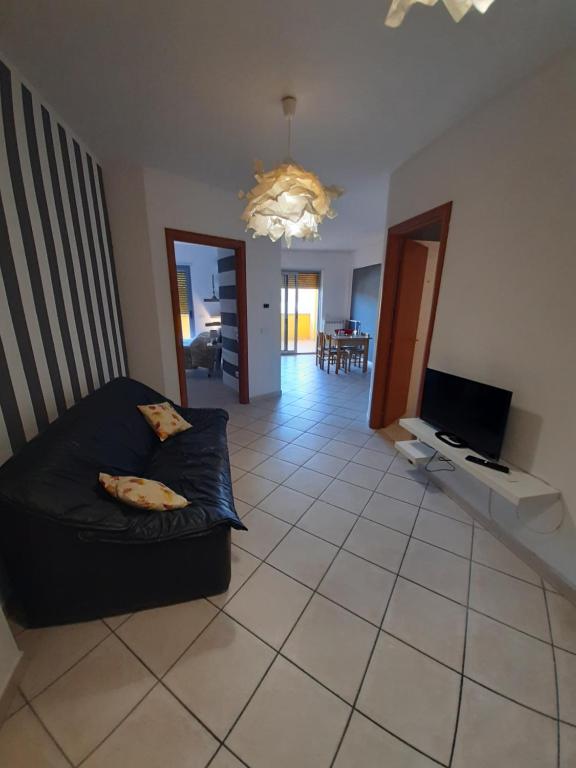 ein Wohnzimmer mit einem Sofa und einem TV in der Unterkunft Casa Vacanze Barrio in Cosenza