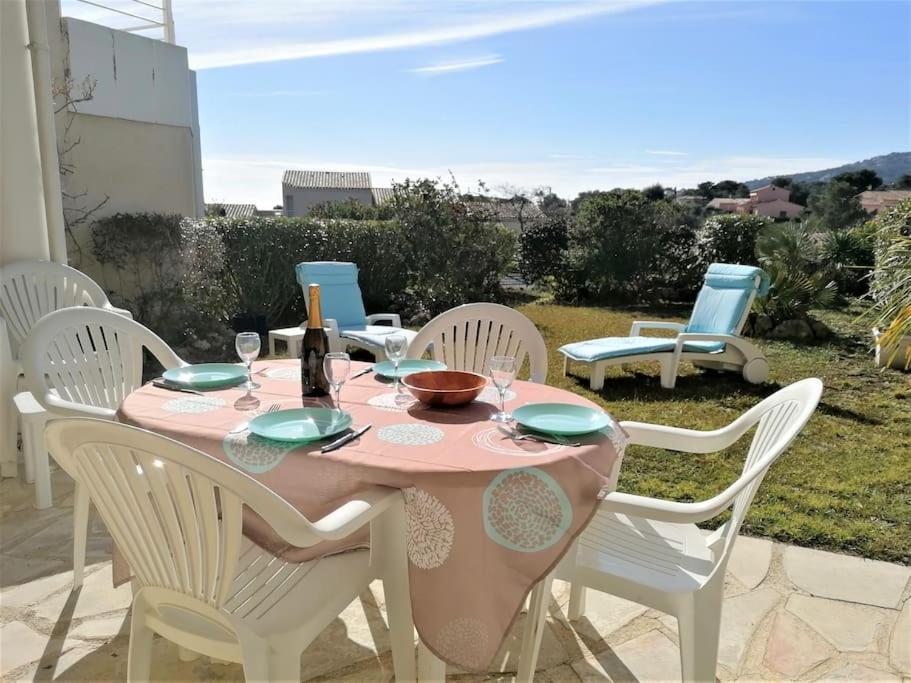 - une table rose avec des chaises blanches et une bouteille de champagne dans l'établissement Appartement Mas de la Mer, 5mn plage, piscine, à Saint-Aygulf