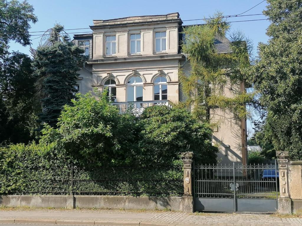 une vieille maison avec une clôture devant elle dans l'établissement Am Elbradweg - Nichtraucher-Gästezimmer Weiland, à Dresde