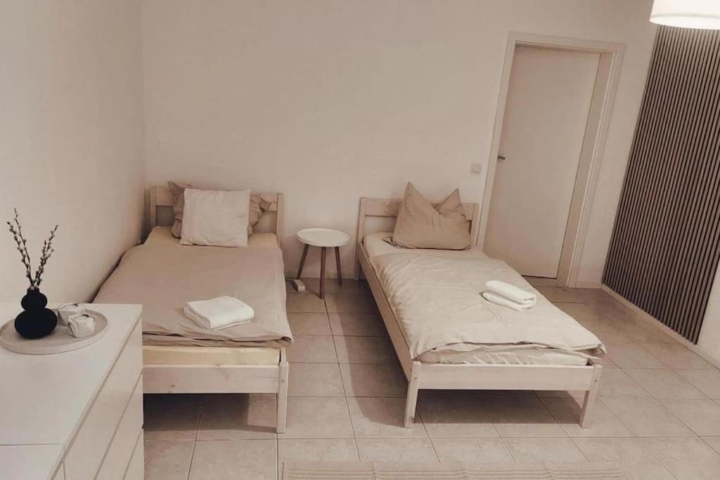 Cette chambre comprend 2 lits et une table. dans l'établissement Wohnung in Dörverden, à Dörverden
