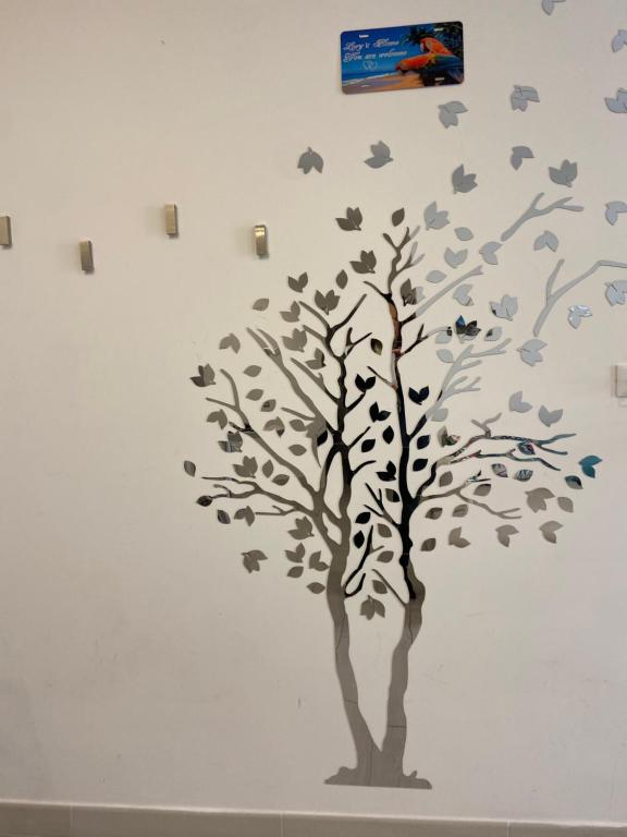 a tree with leaves and birds on a wall at Bari Lory’s Home in Bari