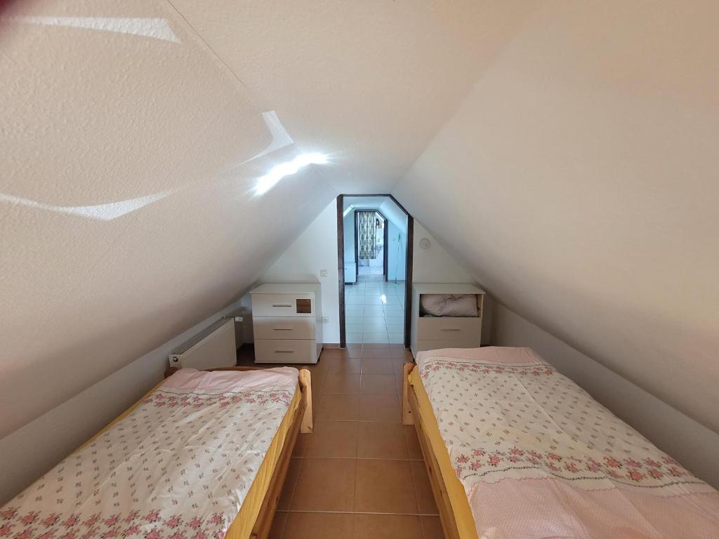 a attic room with two beds and a hallway at Ferienwohnung Schmidt in Neu Sallenthin