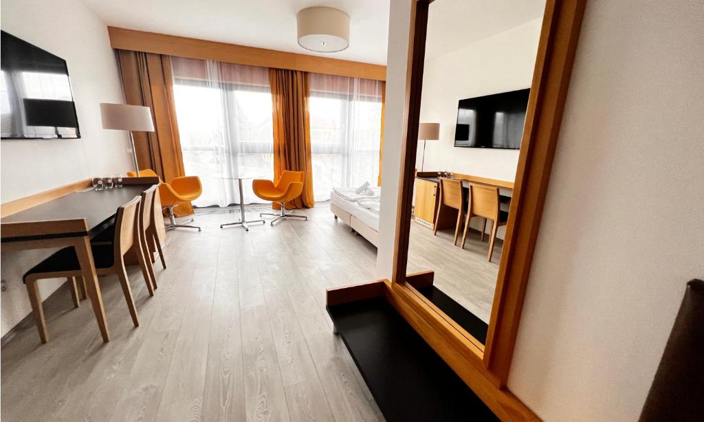 Habitación con espejo, mesa y cama en Hotel Žabčice, en Žabčice