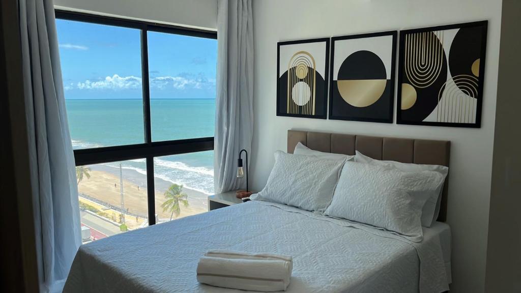 Un dormitorio con una cama con vista al mar. en Beira-Mar Boa Viagem - Ivone Asfora by Bnb Flex, en Recife