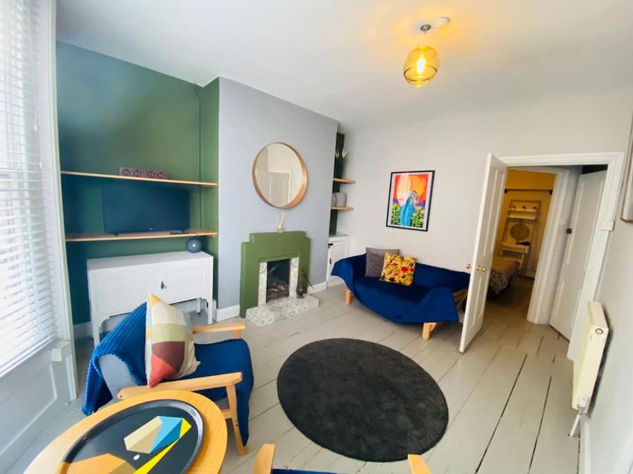 a living room with a blue couch and a mirror at Old Fisherman Nest in Old Town in Hastings