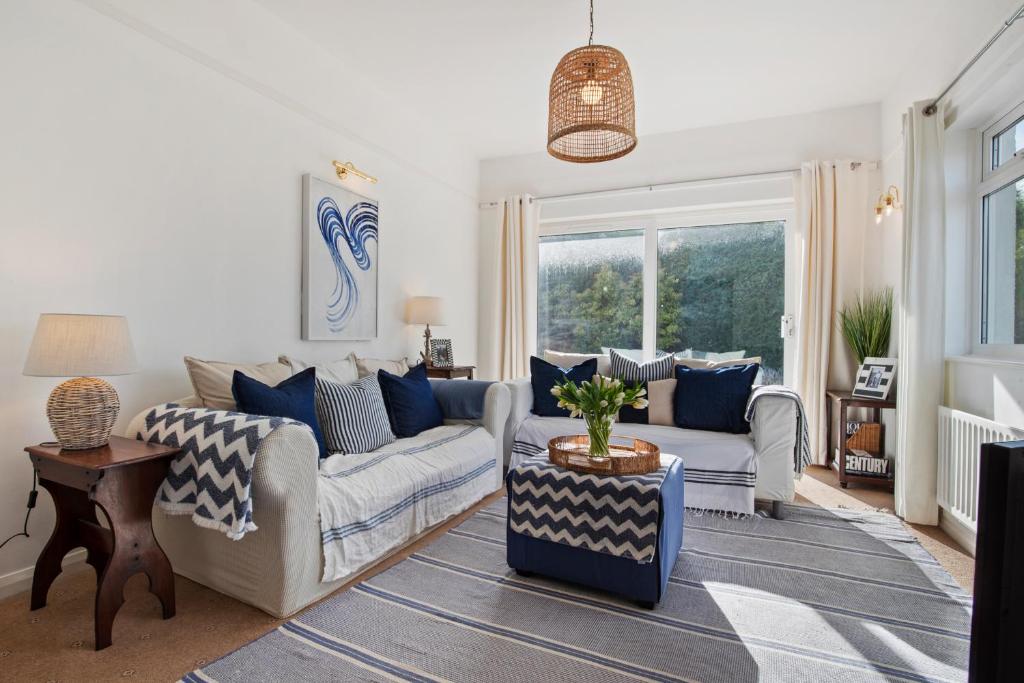 a living room with two couches and a table at Portsea - Sea Views Close to Beach in Saundersfoot