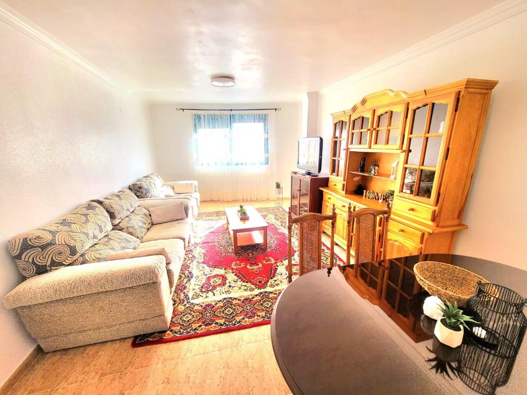 ein Wohnzimmer mit einem Sofa und einem Tisch in der Unterkunft Sea Breeze Apartament in Benicarló