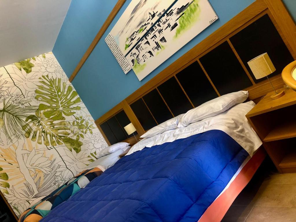 1 cama con edredón azul en una habitación en Terre Iblee Resort en Chiaramonte Gulfi