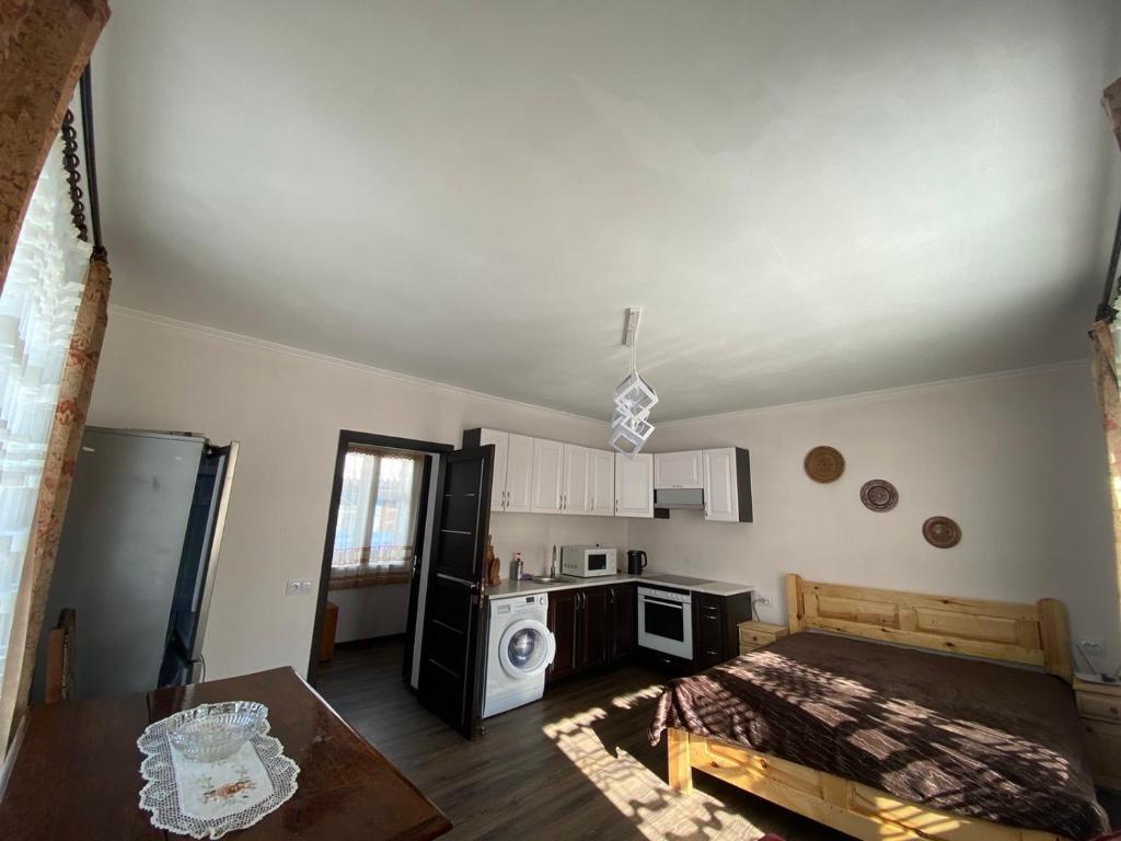 Zimmer mit einem Bett und einer Küche mit einem Kühlschrank. in der Unterkunft Біля річки in Scheschory
