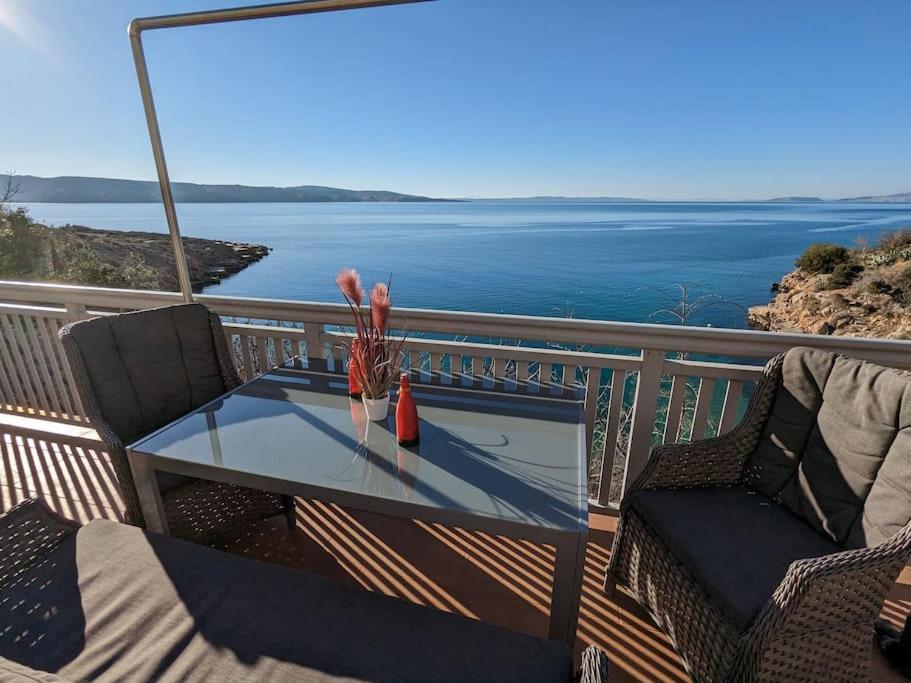 una mesa de cristal en un balcón con vistas al océano en Appartement Blue Lagune 4 Sterne en Prizna