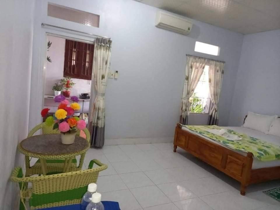 Hoài Oanh homestay في موي ني: غرفة نوم بسرير وطاولة في غرفة