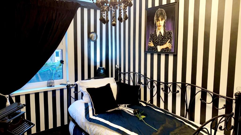 a bedroom with a black and white striped wall at Wednesday's Family Rooms in York