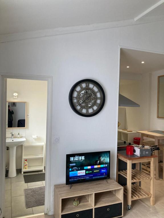 a living room with a clock on the wall at Studio Chez Bob in Montreuil