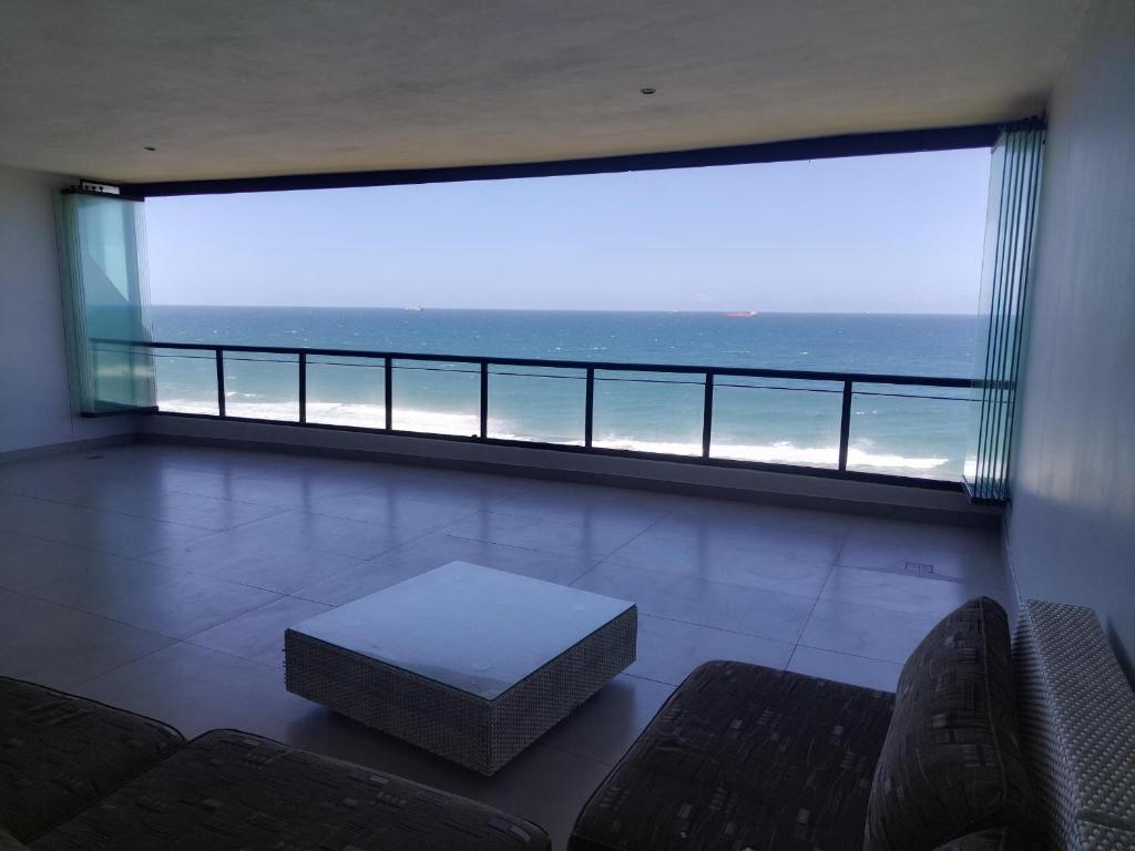 a living room with a large window with a view of the ocean at 504 Coral Reef in La Mercy