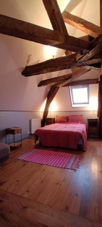 - une chambre avec un lit doté de draps rouges et une fenêtre dans l'établissement Chantilly Villa Quincampoix, à Chantilly