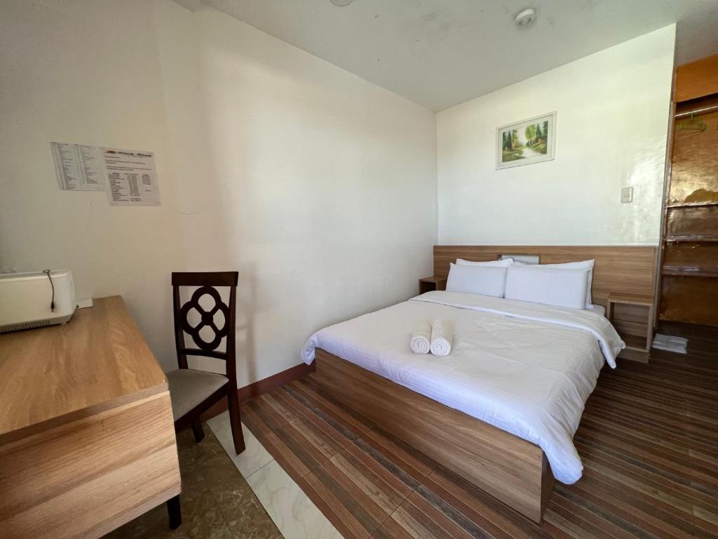a bedroom with a bed with two white pillows on it at GingGing Hotel And Resort in Oslob