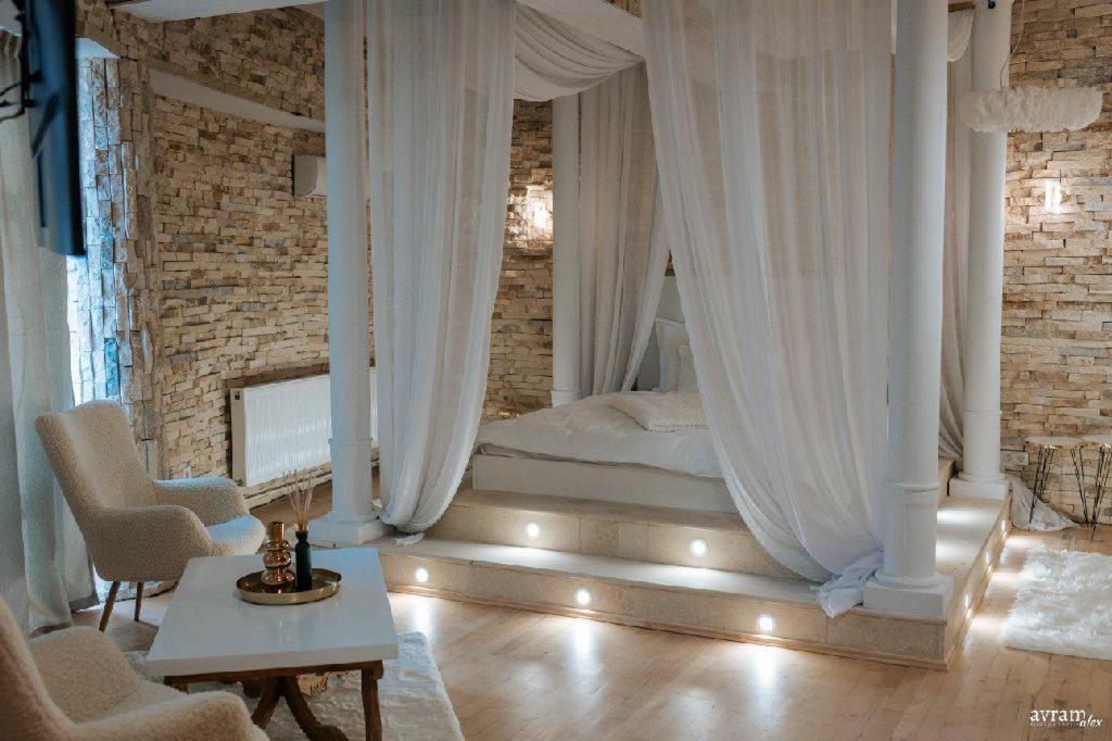 阿爾巴·尤利亞·的住宿－Castle Transylvania，一间卧室配有白色窗帘的床