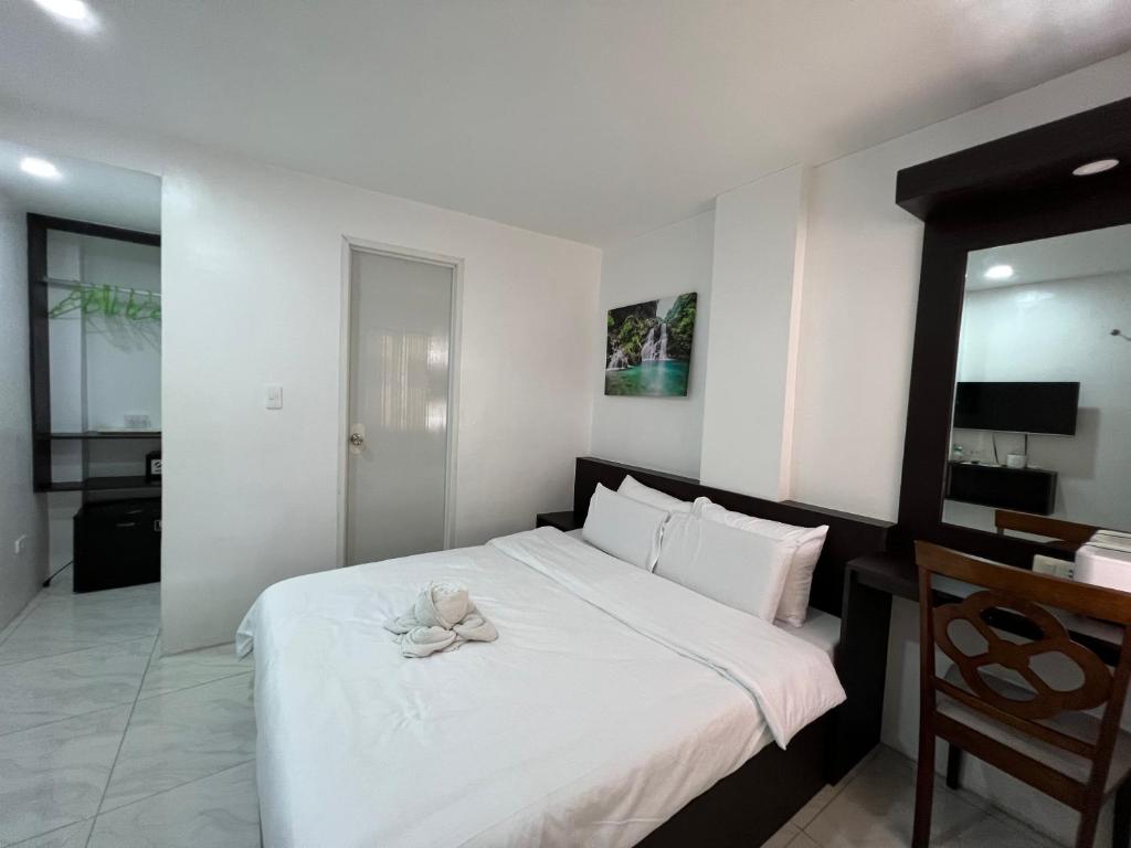 a bedroom with a bed with a stuffed animal on it at GingGing Hotel And Resort in Oslob
