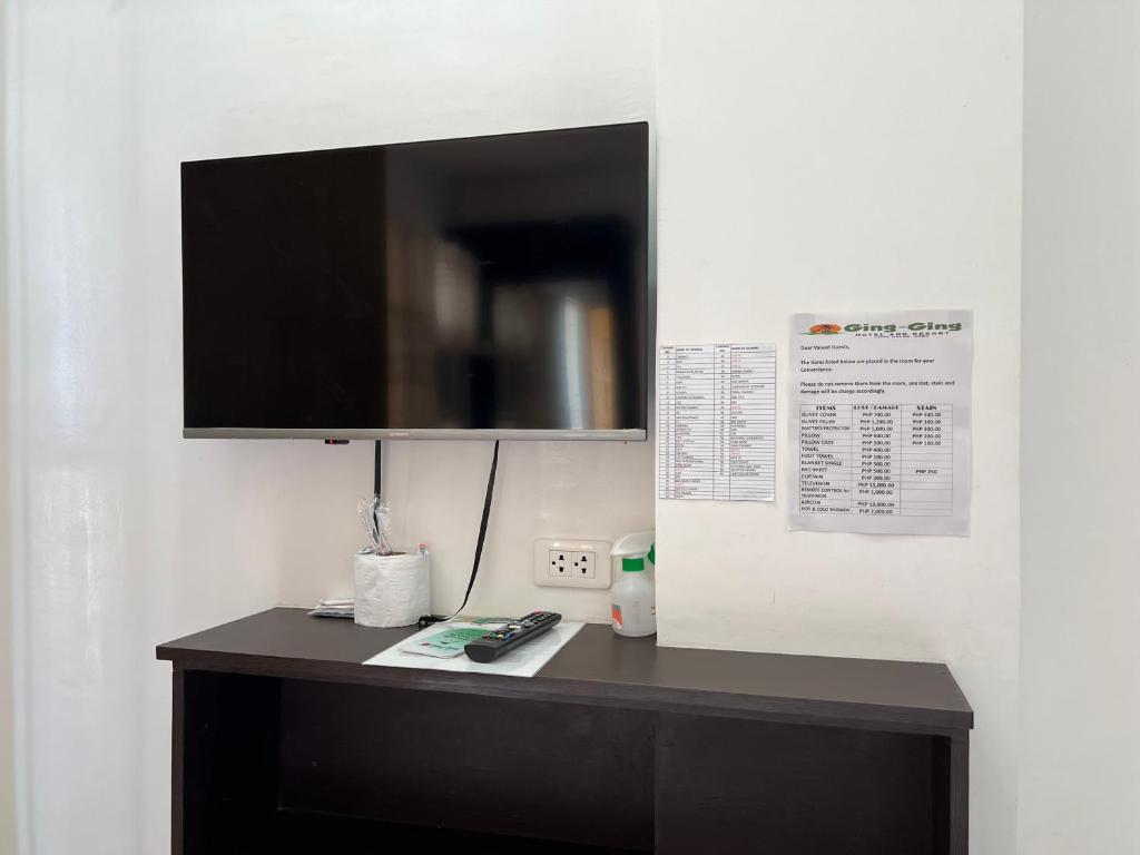 a black desk with a television on a wall at GingGing Hotel And Resort in Oslob