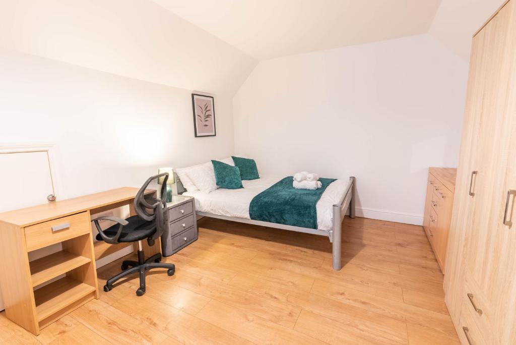 a bedroom with a bed and a desk and a desk at Beautiful 3 bedroom house, Ashbnhm,Luton free parking in Luton