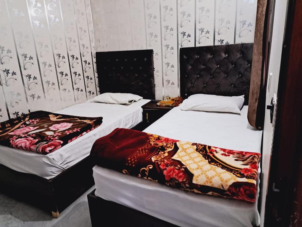 two beds in a room with two bedsskirts at Lords Hotel in Lahore