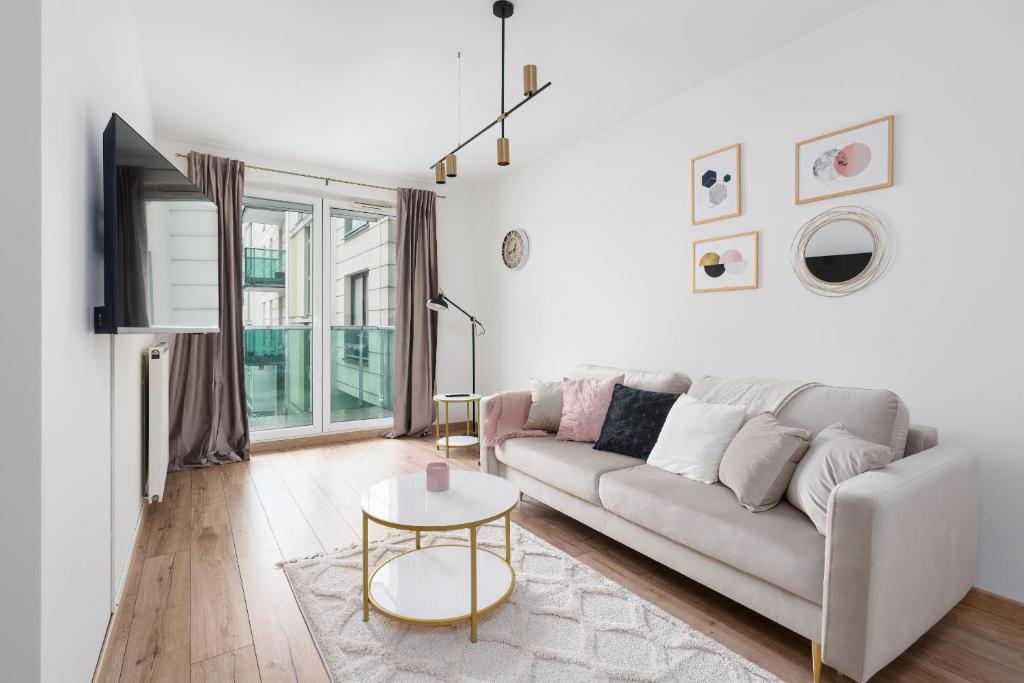uma sala de estar branca com um sofá e uma mesa em Arena Lux Apartment Kasprowicz Park by Renters Prestige em Poznań