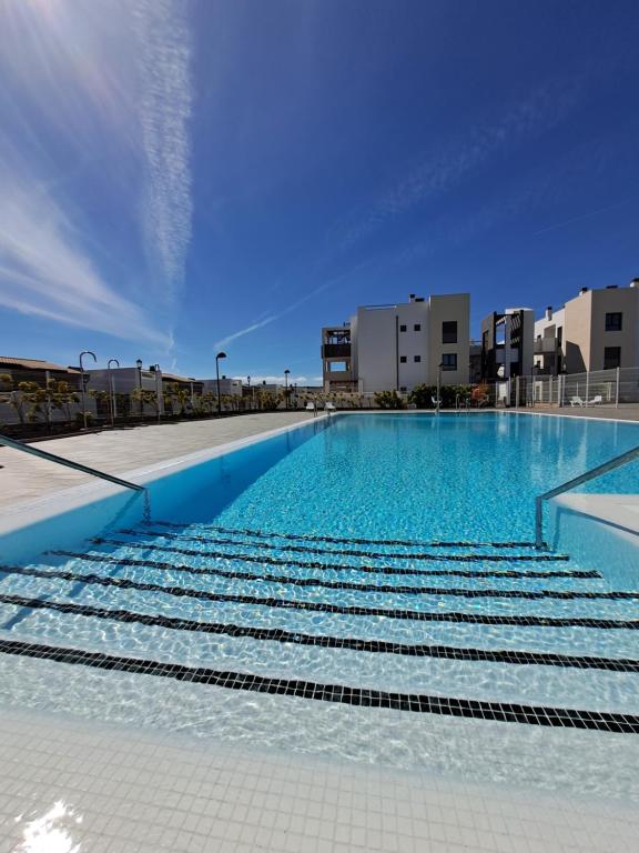 a large swimming pool with blue water in a city at Casa Maco in Costa de Antigua