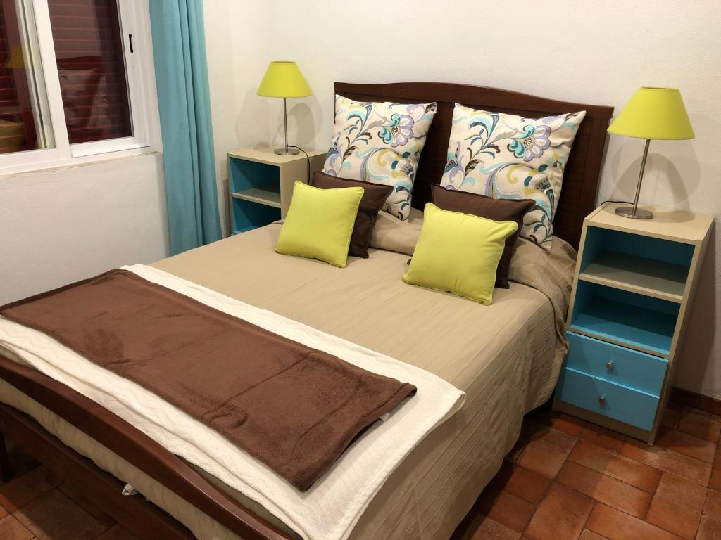 ein Schlafzimmer mit einem großen Bett mit zwei Nachttischen in der Unterkunft Quintinha da Evangelina in Açafora