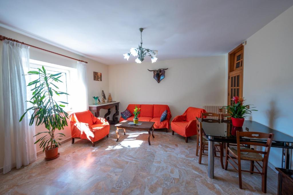 ein Wohnzimmer mit roten Stühlen und einem Tisch in der Unterkunft Agriturismo Caperroni in Pescopagano