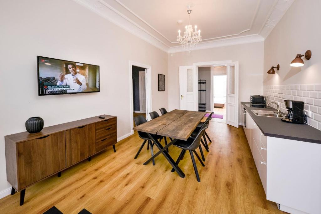 uma cozinha e sala de jantar com uma mesa de madeira em Old Town Apartments em Berlim