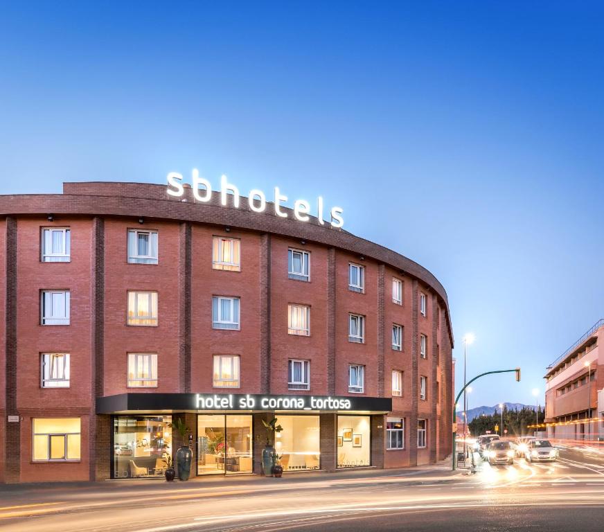 a large red brick building with a sign on it at Apartaments SB Corona Tortosa in Tortosa