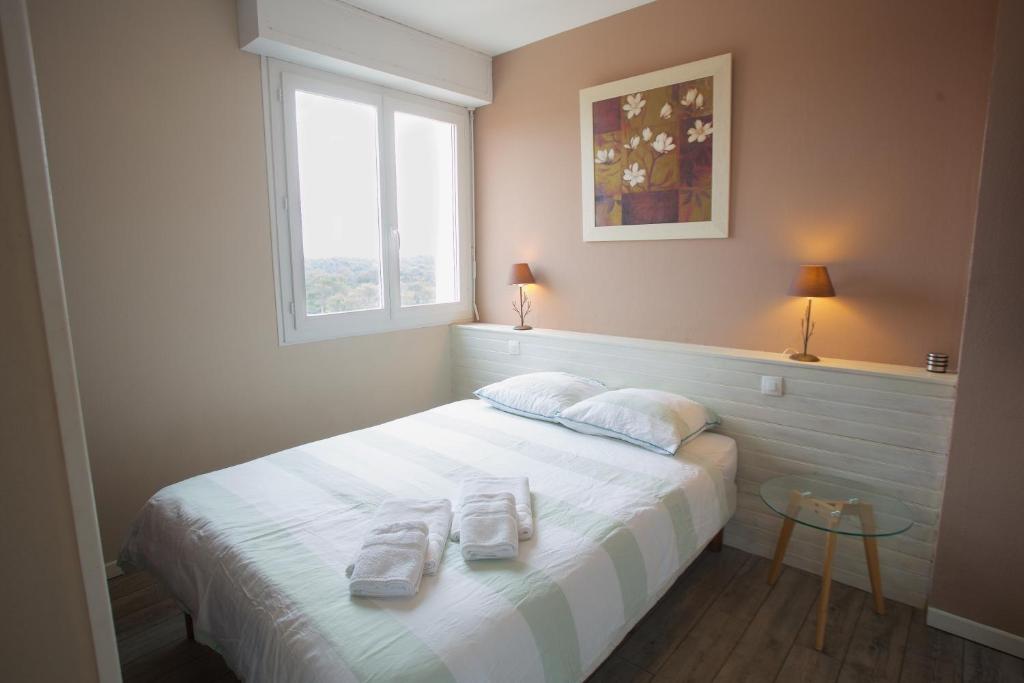 um quarto com uma cama com duas toalhas em Hossegor - Plage 100m - Surf - Famille - Couple em Soorts-Hossegor