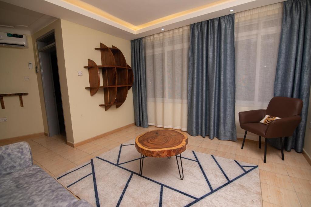 a living room with a couch and a table and chairs at Olori Flats in Munyonyo