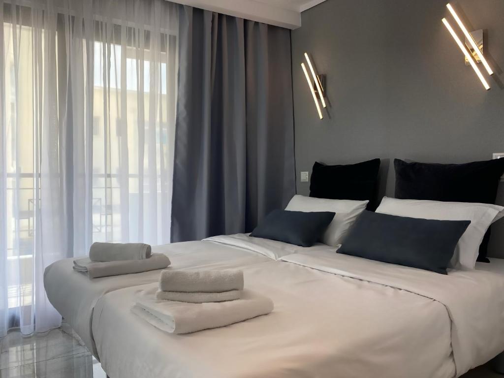 ein großes weißes Bett mit zwei Handtüchern darüber in der Unterkunft Casa Primavera in Thessaloniki