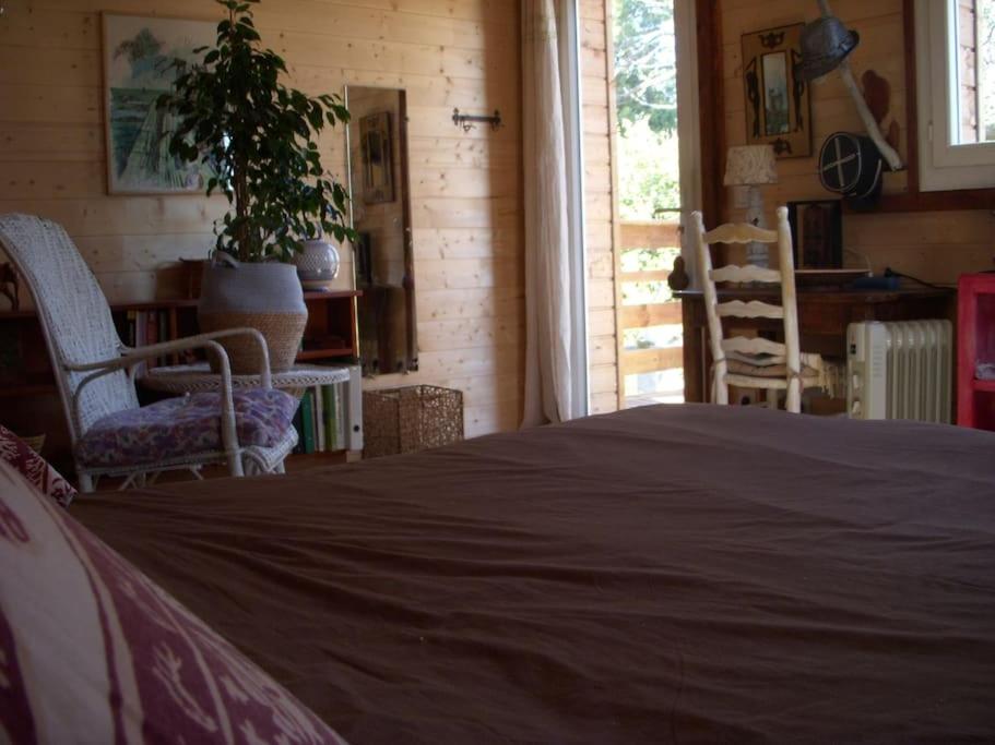 a bedroom with a bed and two chairs and a table at Un havre de paix in Aigues-Vives