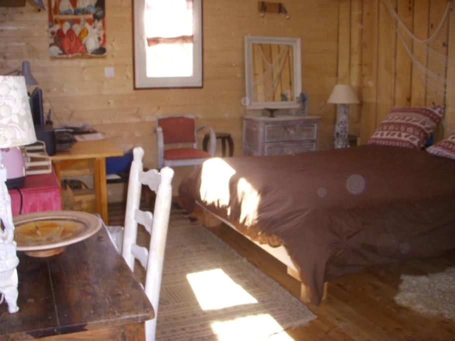 a bedroom with a large bed in a log cabin at Un havre de paix in Aigues-Vives