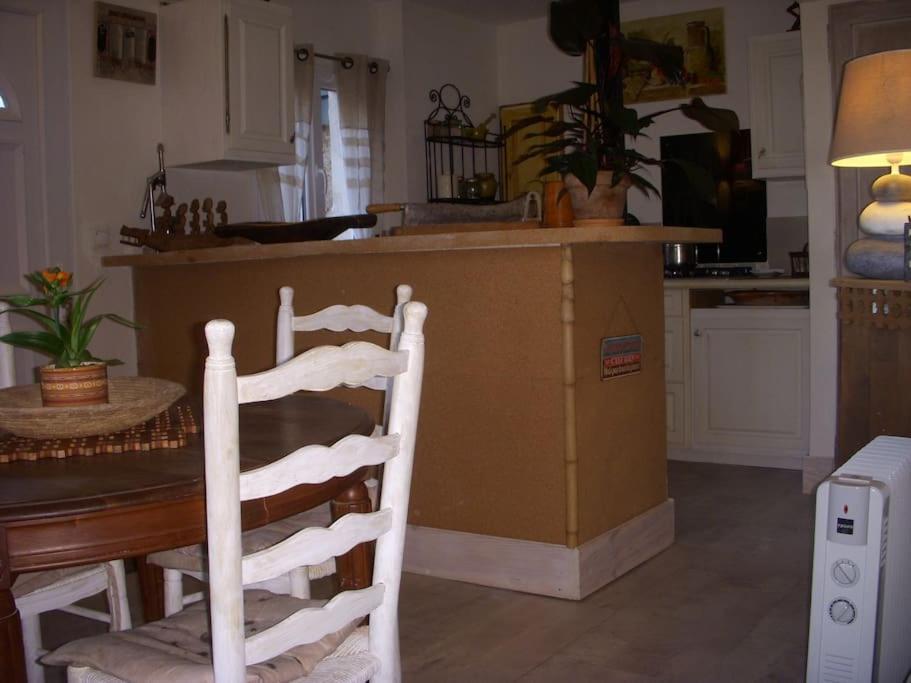 a kitchen with a table and two white chairs at Un havre de paix in Aigues-Vives
