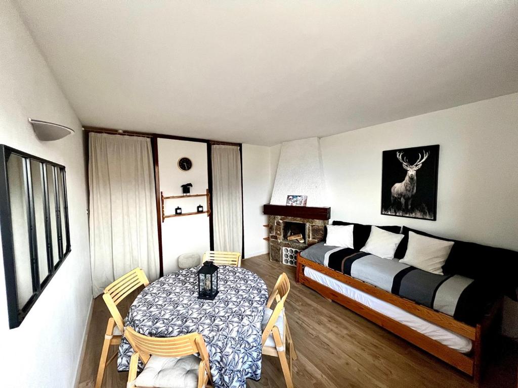 une chambre avec un lit, une table et des chaises dans l'établissement Studio Saint Lary Pla d adet 5 couchages, à Saint-Lary-Soulan