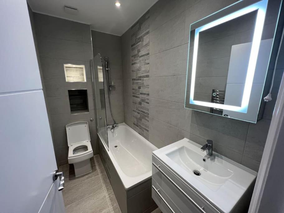 a bathroom with a sink and a tub and a toilet at Cosy Entire Flat in Kings Cross in London