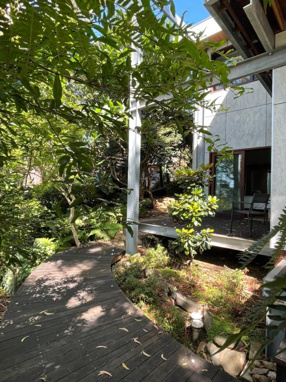 una pasarela frente a una casa con árboles en Tranquil Garden Studio, en Wollongong