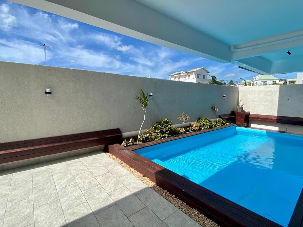 una piscina en el patio trasero de una casa en Sandstone Apartment a walk to the beach, en Flic en Flac