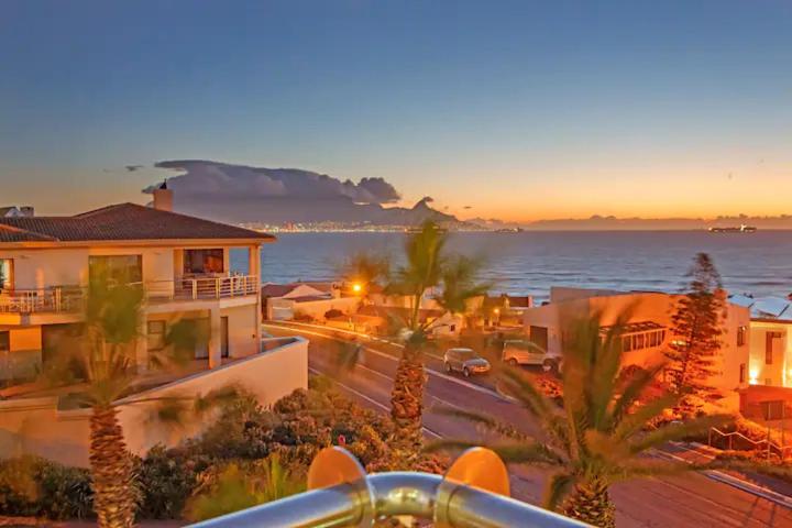 ケープタウンにあるSir David Baird 22のヤシの木と海の景色を望む建物