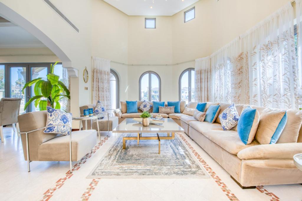 ein Wohnzimmer mit einem Sofa und einem Tisch in der Unterkunft Stunning Villa with Private Pool & Beach Access in Dubai