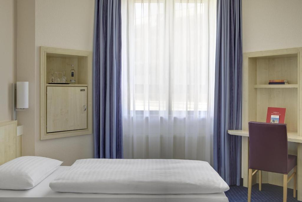 Postel nebo postele na pokoji v ubytování IntercityHotel Freiburg