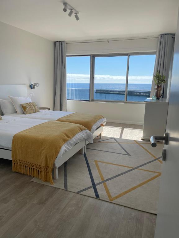 - une chambre avec un grand lit et une grande fenêtre dans l'établissement top floor avenida arriaga 802, à Funchal