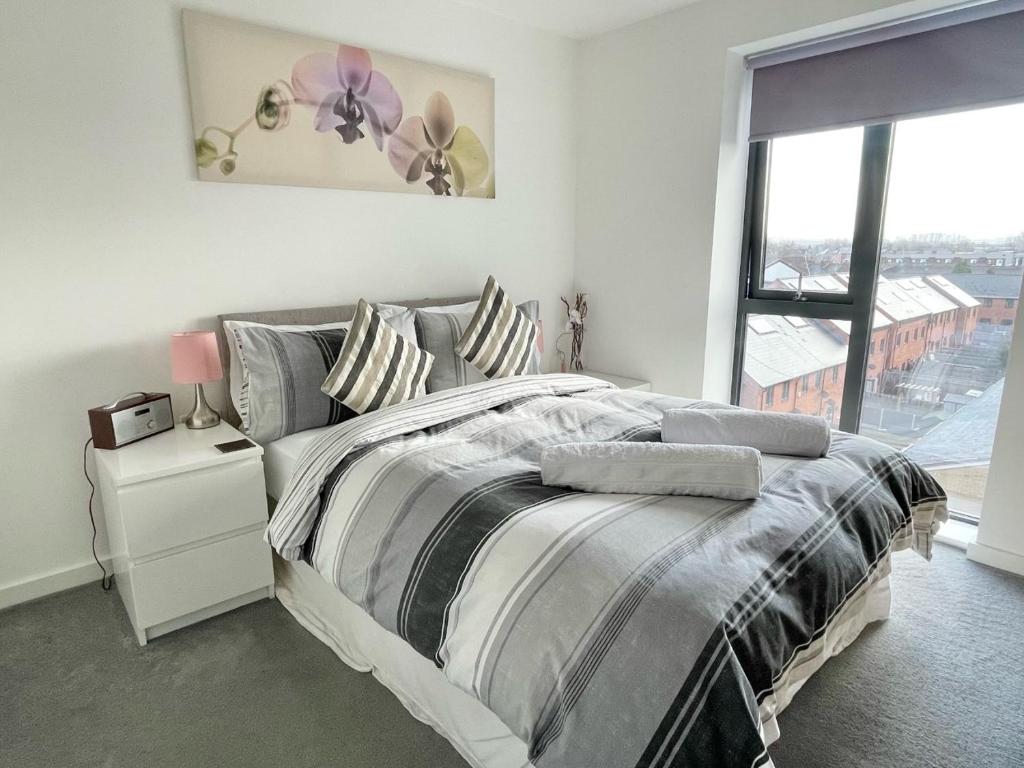 um quarto com uma cama grande e uma janela em Bridgewater House - Private Room & Bathroom Near Etihad and CoOp Arena em Manchester