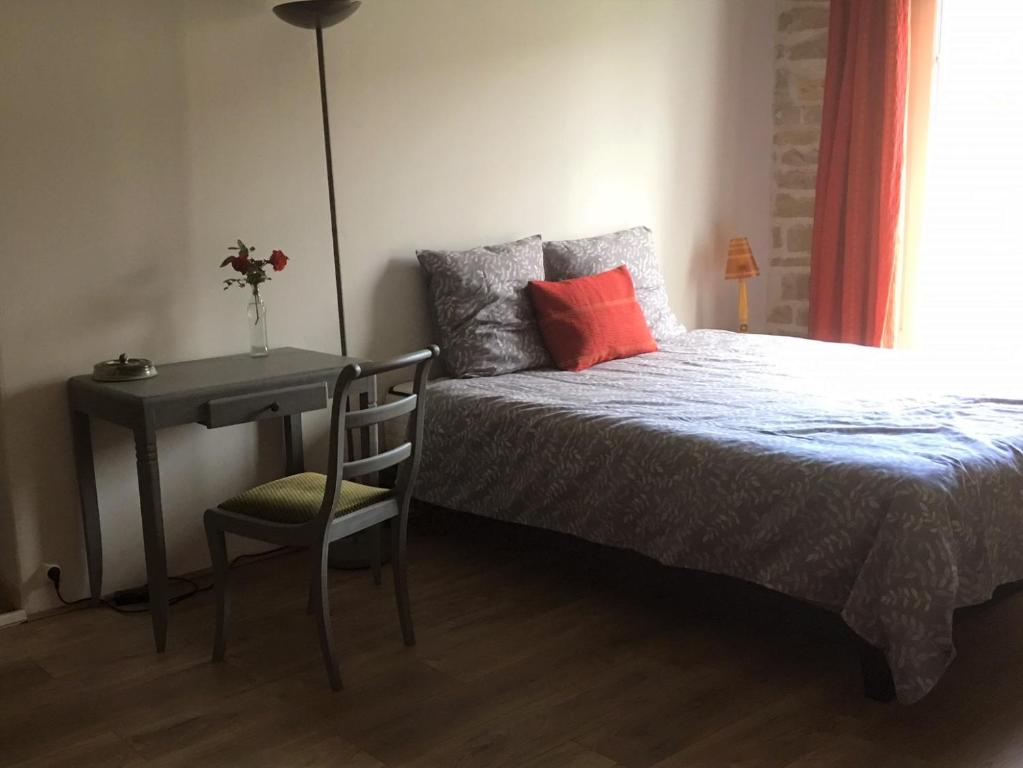 a bedroom with a bed and a desk and a chair at 2 chambres privées au calme à la Maison des Bambous in Dijon