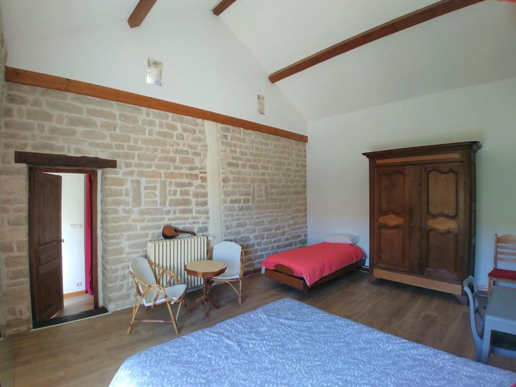 a bedroom with two beds and a brick wall at 2 chambres privées au calme à la Maison des Bambous in Dijon