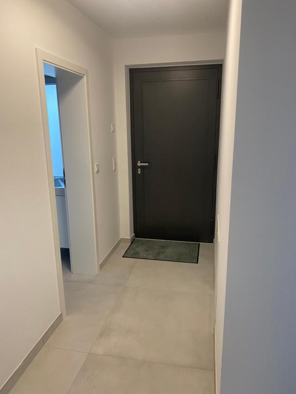 a hallway with a black door and a tile floor at Charmante Ferienwohnung-Neubau- in Taunusstein