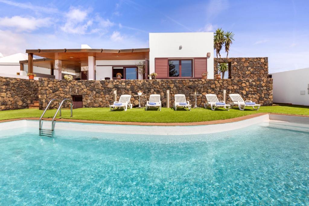 una villa con piscina di fronte a una casa di Home2Book Luxury Villa Playa Honda, Private Pool a Playa Honda